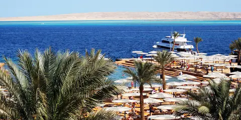 Palmer, parasoller og en hotelstrand med lystbåd ved Det Røde Hav i Hurghada
