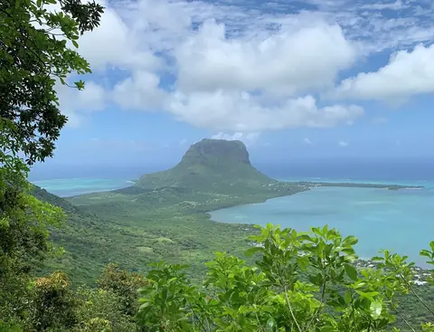 Bjerget Le Morne Brabant på en halvø i en turkis lagune, set fra de grønne højder ved Chamarel