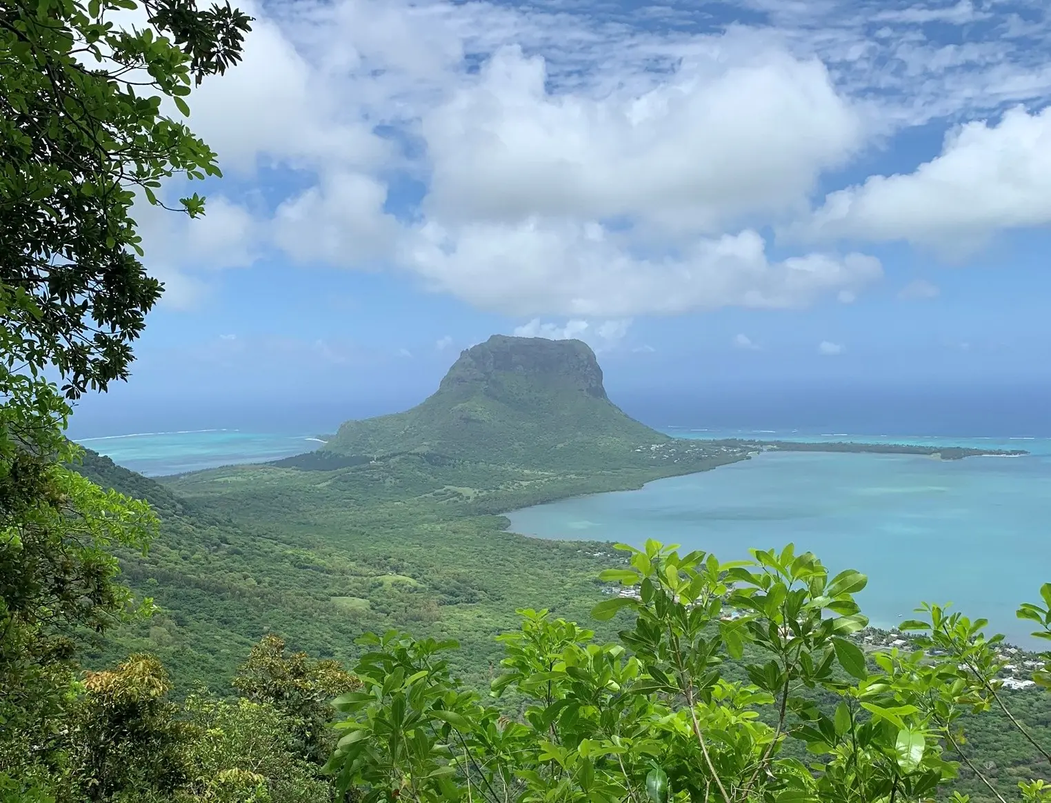 Bjerget Le Morne Brabant på en halvø i en turkis lagune, set fra de grønne højder ved Chamarel