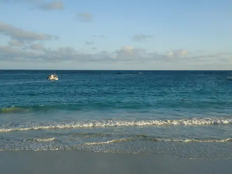 Blåt hav med lave bølger, der ruller ind mod Lido-stranden i Mogadishu under en lys himmel