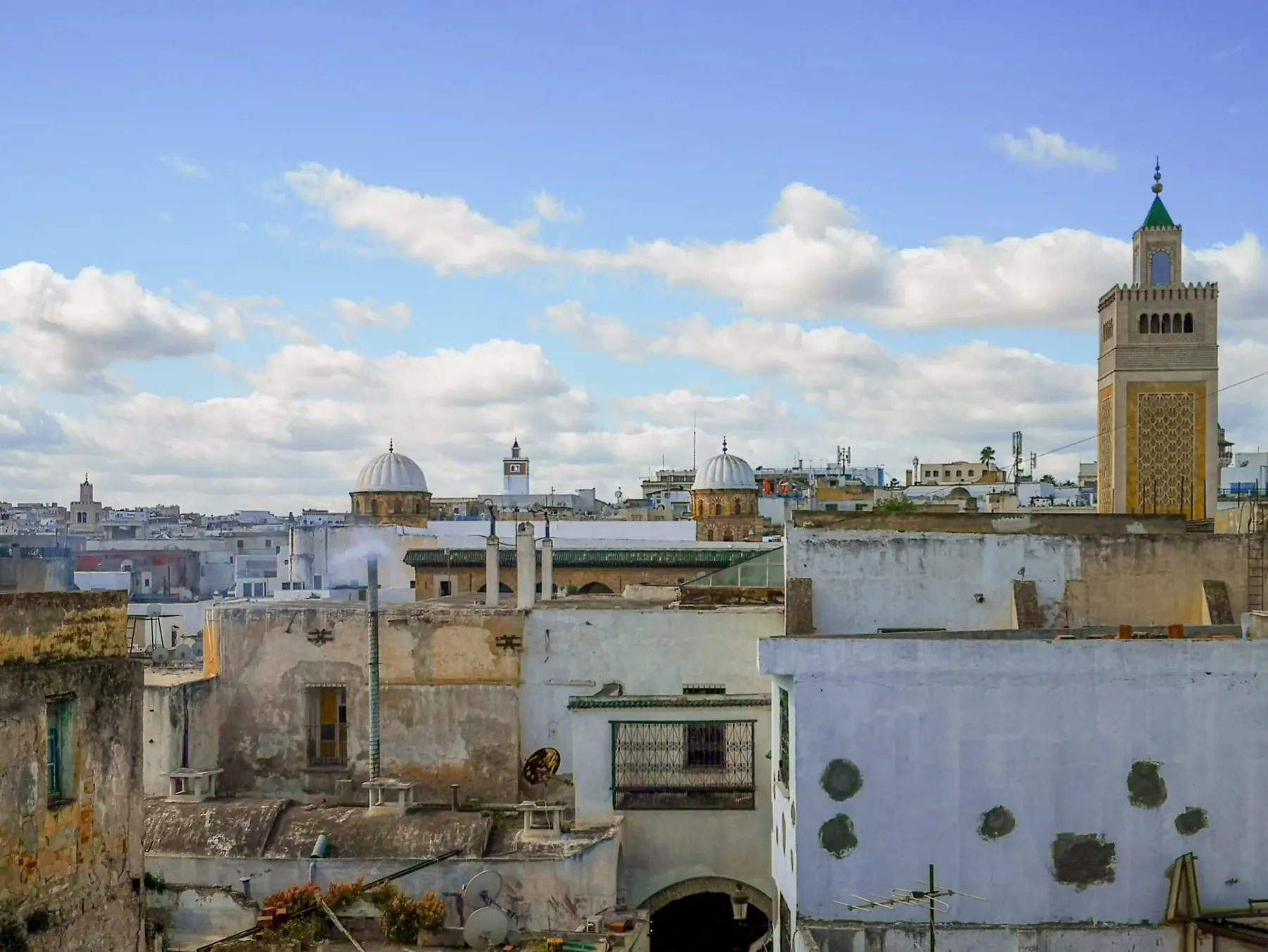 Tagene i Tunis' medina med hvide kupler og Zitouna-moskeens minaret under en blå himmel