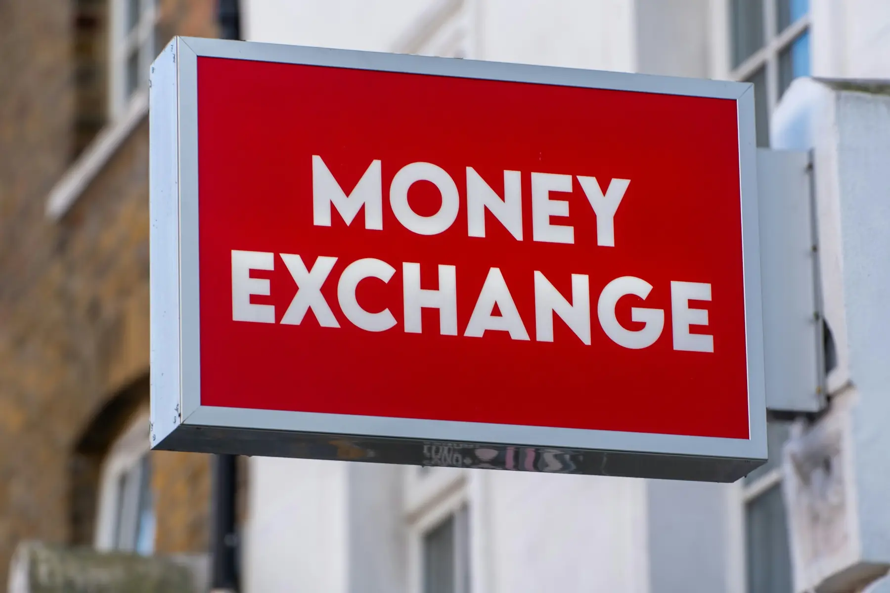 Rødt skilt med teksten Money Exchange på en husfacade
