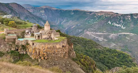 Klostret Tatev på en klippeafsats over en dyb, grøn bjergdal i det sydlige Armenien