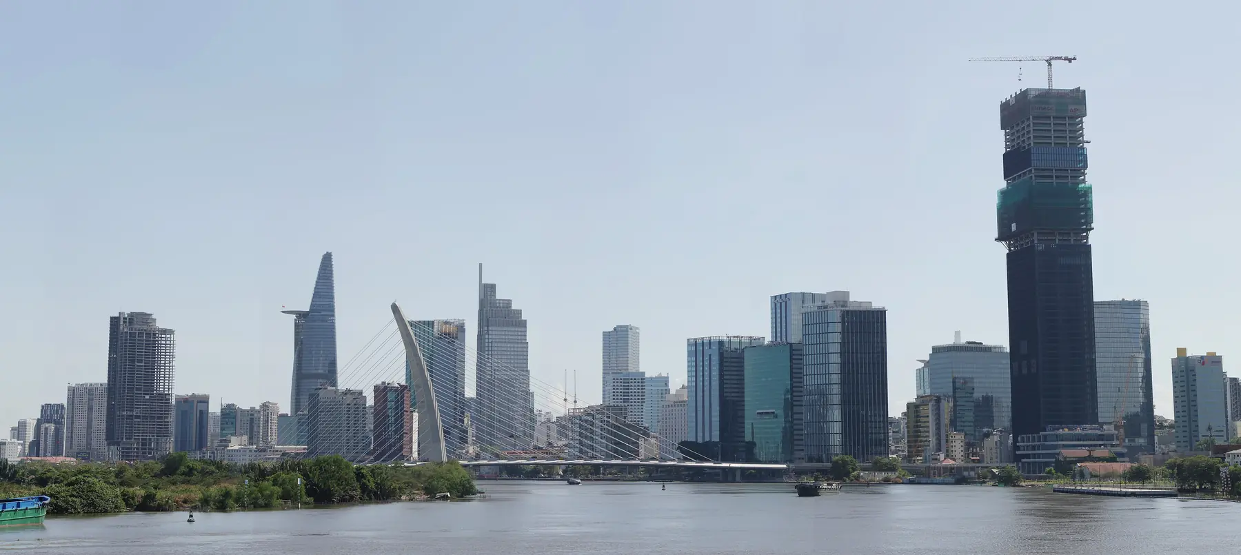 Skylinen i Ho Chi Minh City med Bitexco-tårnet og en skråstagsbro over Saigon-floden