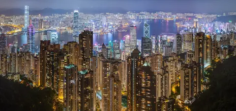 Hongkongs oplyste skyskrabere og havnen Victoria Harbour set fra Victoria Peak en aften