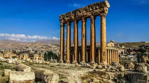 Jupitertemplets seks høje søjler mellem antikke ruiner i Baalbek under blå himmel
