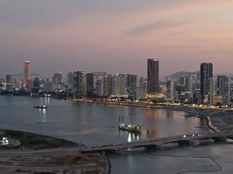 George Towns skyline ved havet i skumringen med Komtar-tårnet og en bro over vandet på Penang