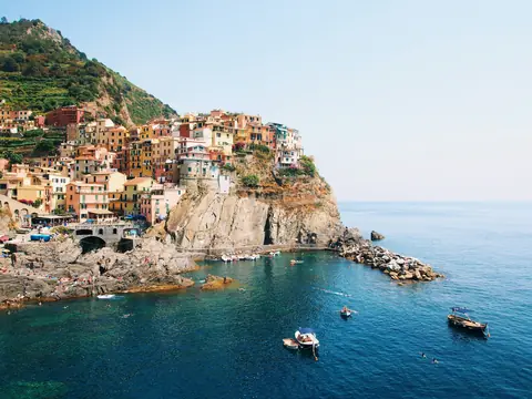 Farverige huse på klippen over havet og små både i bugten ved Manarola i Cinque Terre