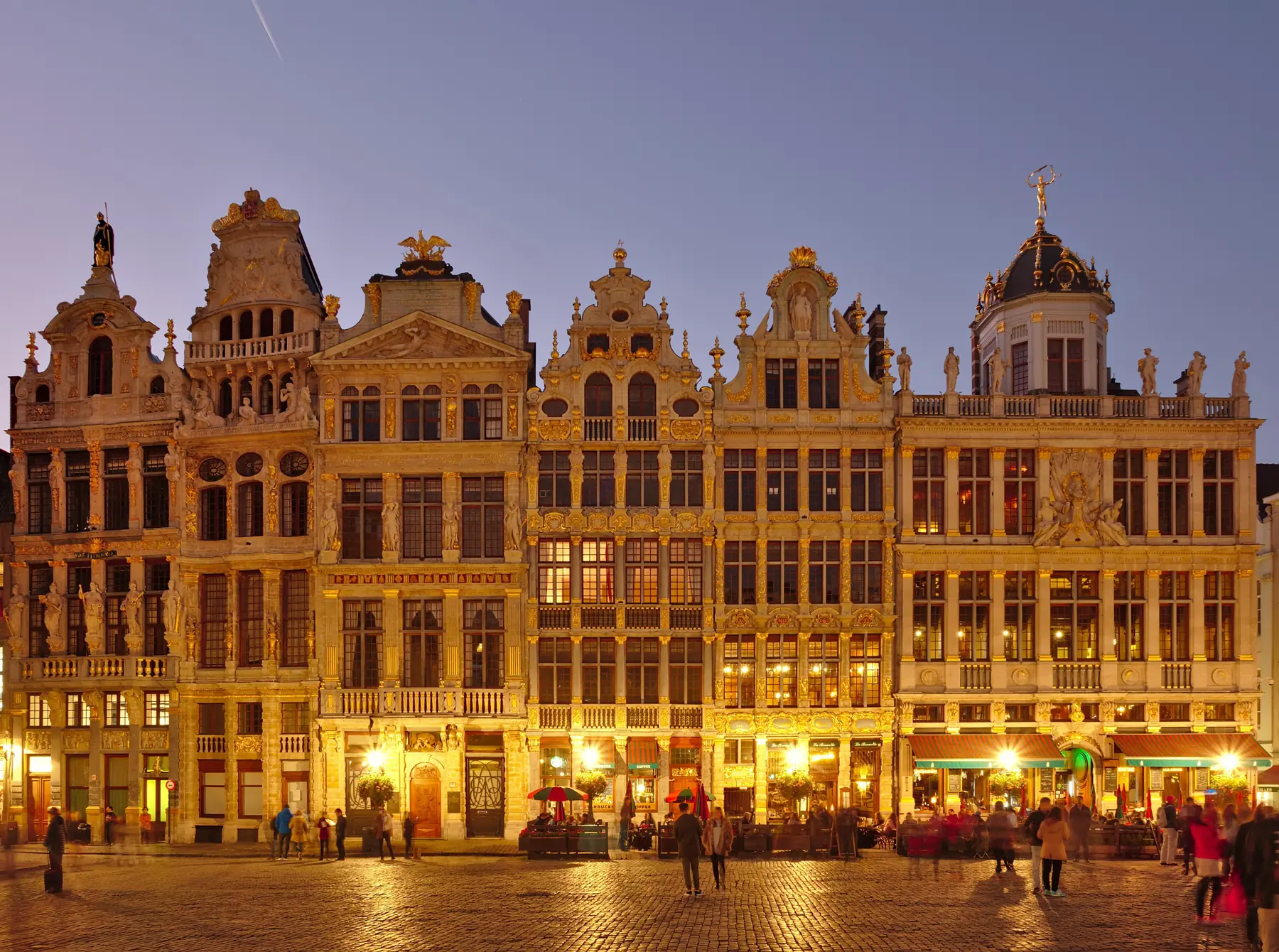 Oplyste lavshuse med forgyldte gavle på Grand-Place i Bruxelles i skumringen