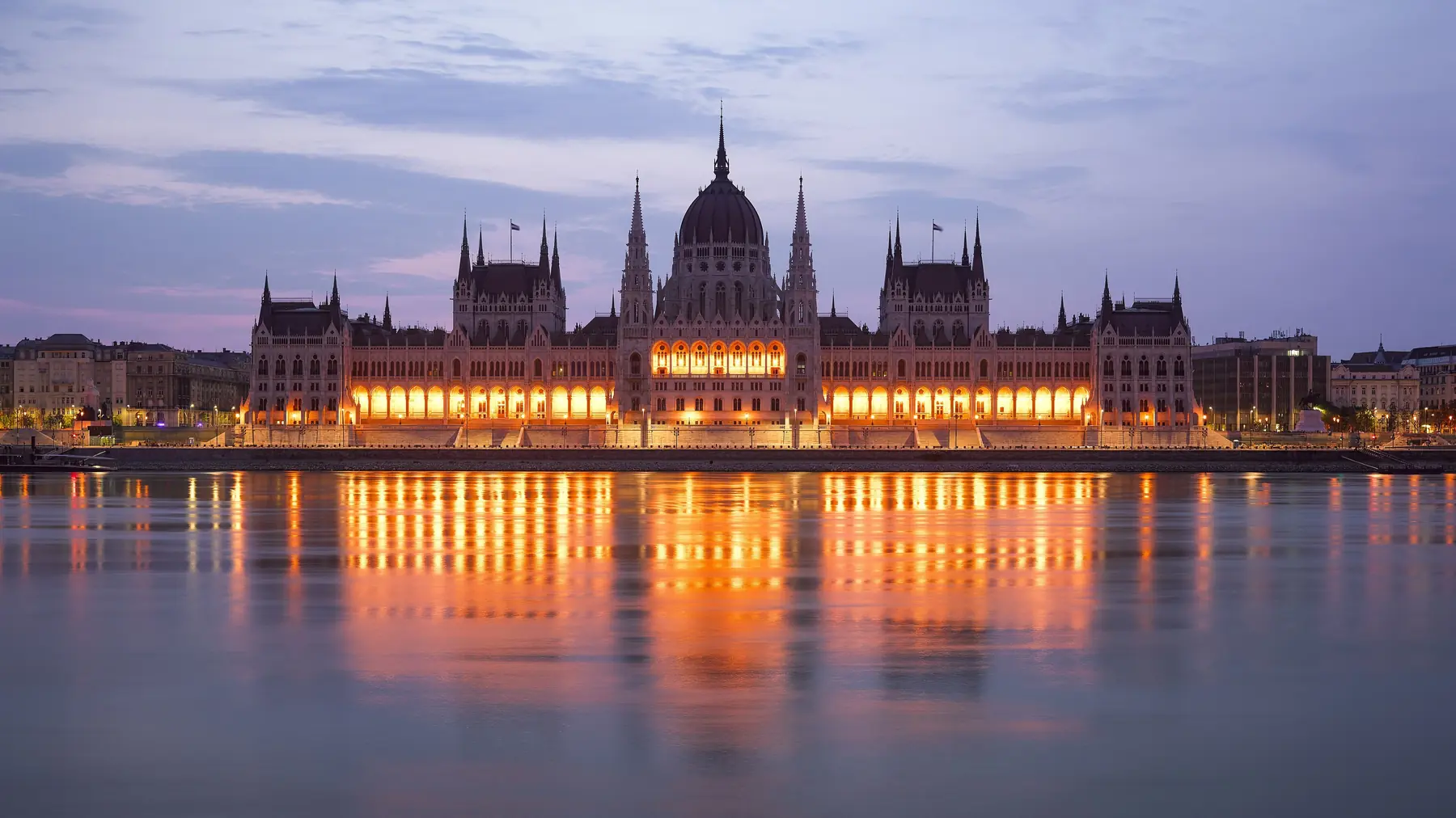 Det ungarske parlament i Budapest oplyst ved skumring og spejlet i Donau