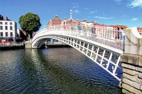 Den hvide støbejernsbro Ha'penny Bridge over floden Liffey i Dublin en solskinsdag