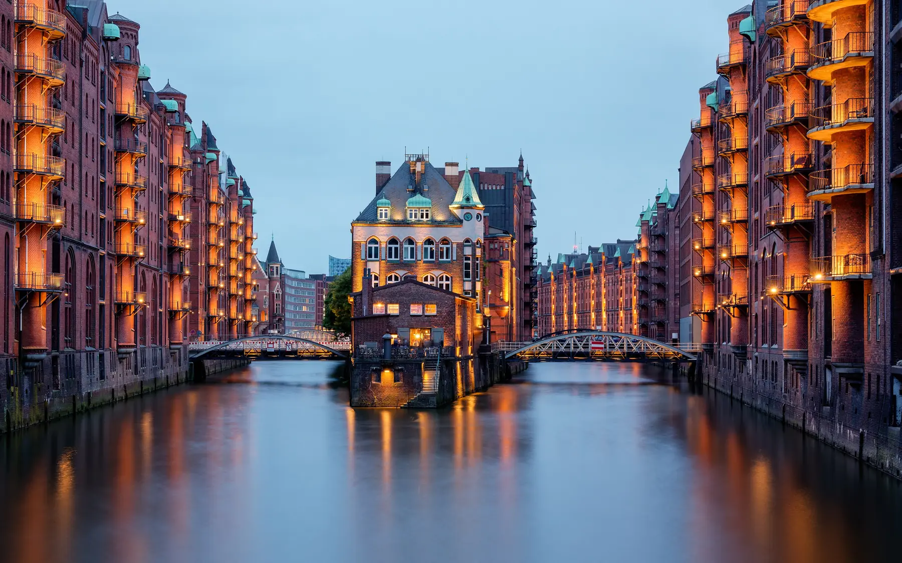 Wasserschloss og oplyste røde pakhuse langs kanalen i Speicherstadt i Hamborg ved skumring