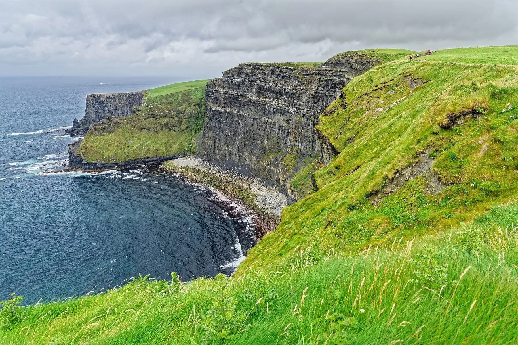 Stejle grønne klipper, der styrter ned i Atlanterhavet ved Cliffs of Moher på Irlands vestkyst