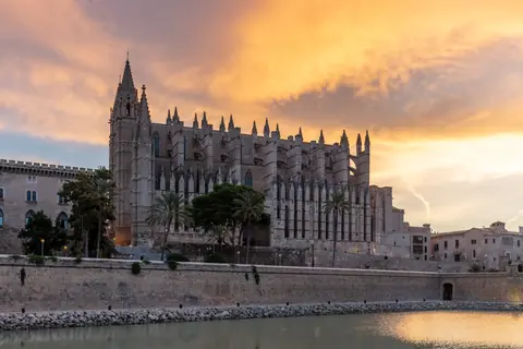 Katedralen La Seu i Palma de Mallorca over bymuren og Parc de la Mar ved solnedgang