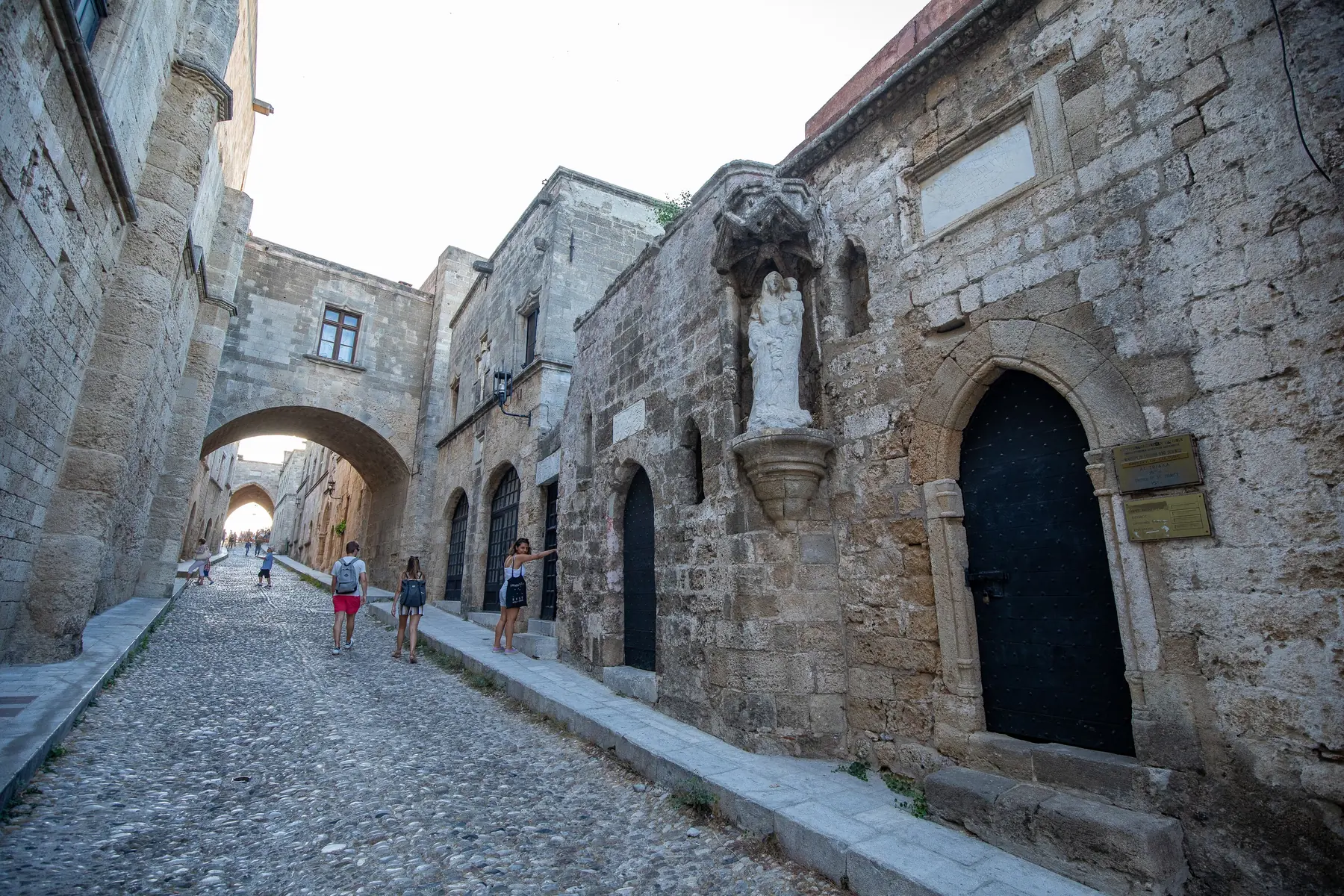 Den brolagte Ridderstræde i Rhodos' middelalderlige gamle by med stenhuse og en buegang