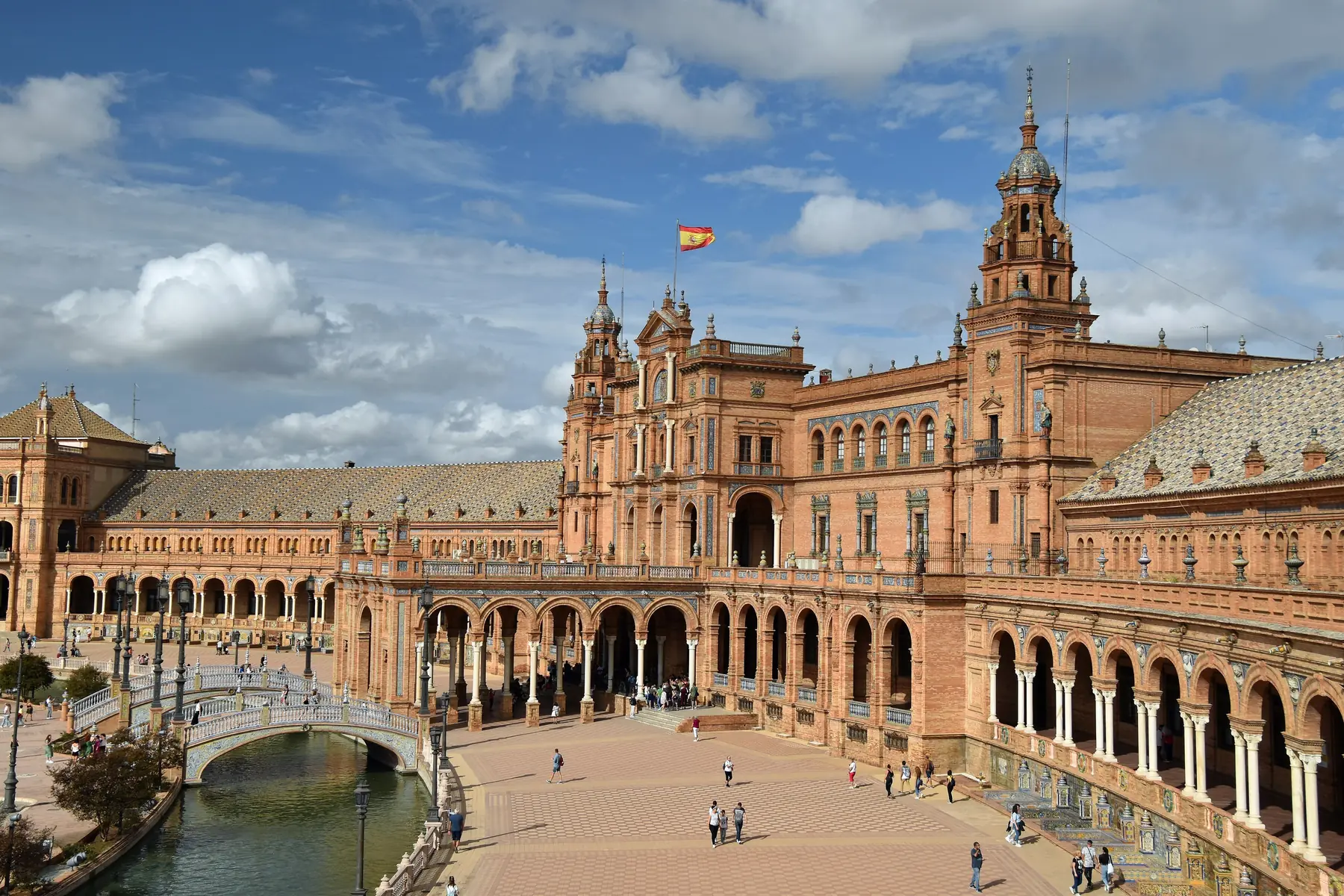 Plaza de España i Sevilla med det buede murstenspalads, kanalen og en lille bro
