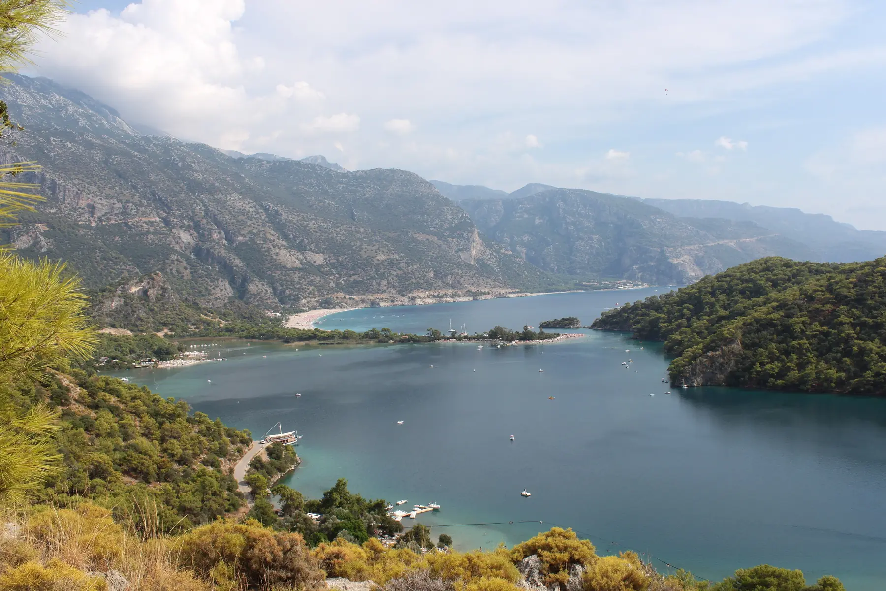 Udsigt over lagunen ved Ölüdeniz med turkist vand, sandtangen og skovklædte bjerge langs den tyrkiske kyst