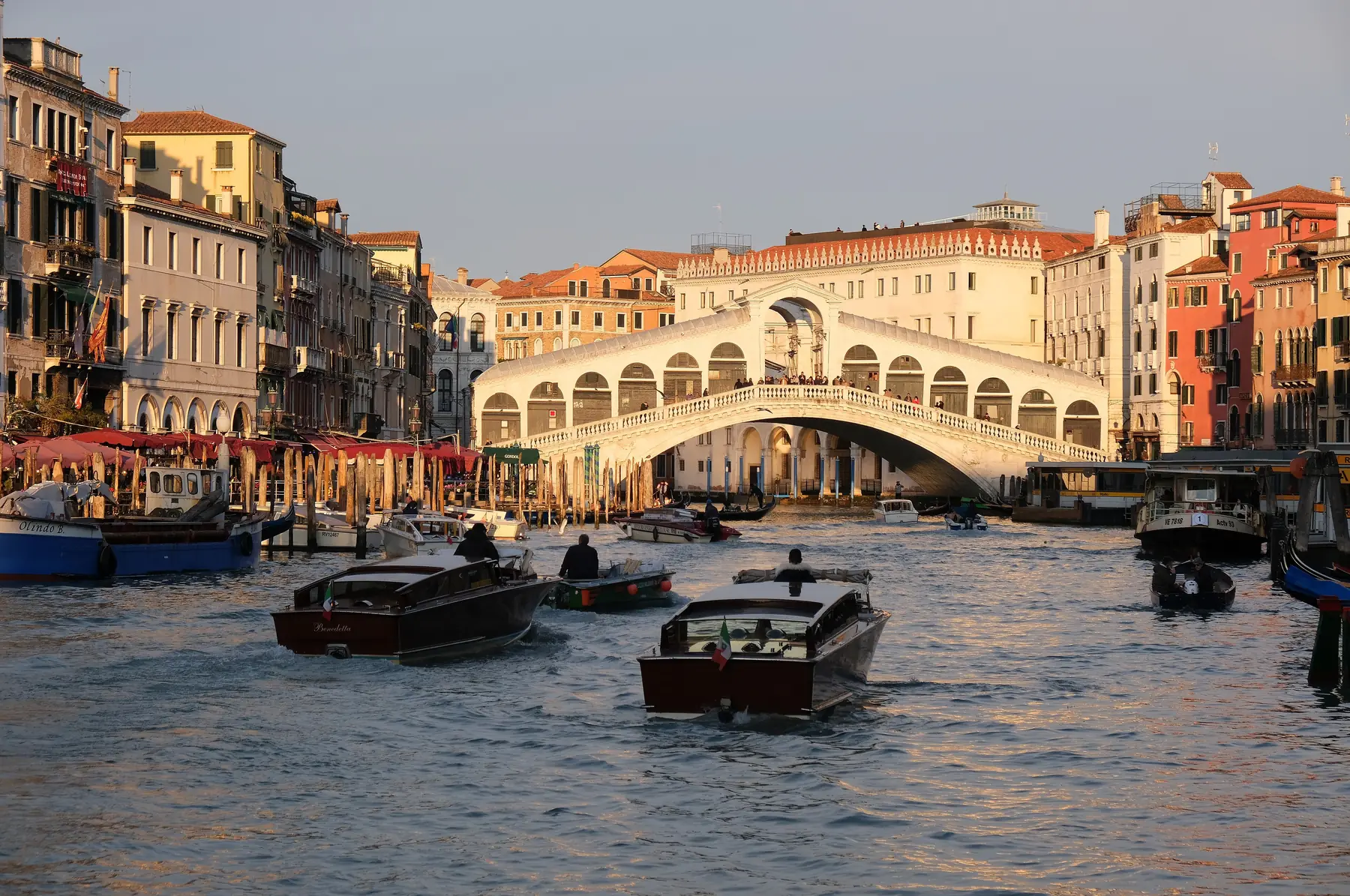 Motorbåde på Canal Grande foran Rialtobroen i Venedig i aftenlys