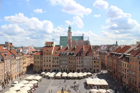 Det gamle torv i Warszawa med farverige borgerhuse og caféparasoller set fra oven