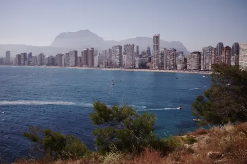 Benidorms højhuse langs Levante-stranden og bjergene bag set over bugten
