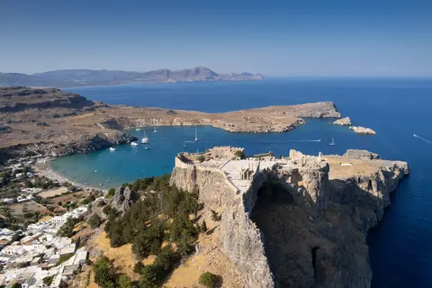 Luftfoto af akropolis i Lindos på Rhodos på klippen over den blå bugt og hvide huse