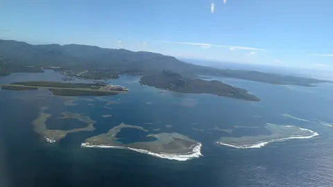 Pohnpeis lagune med koralrev og små øer foran den grønne hovedø, set fra et fly