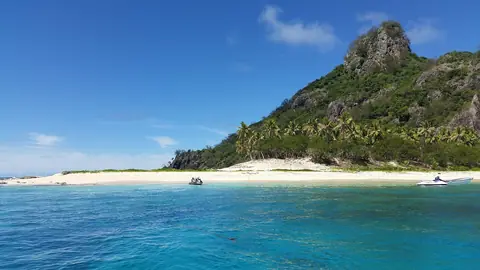 Øen Monuriki med en klippetop, palmer og hvid sandstrand ved turkist vand