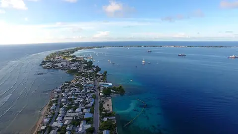 Den smalle atol Majuro med huse langs en lang landstrimmel mellem lagunen og havet, set fra luften