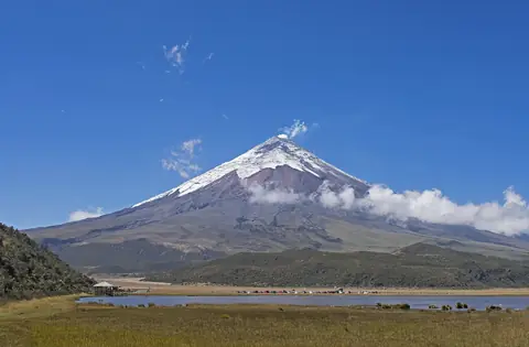 Den snedækkede vulkan Cotopaxi over højsletten og lagunen Limpiopungo