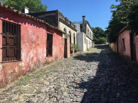 Brostensgaden Calle de los Suspiros med gamle lyserøde og hvide huse i Colonia del Sacramento